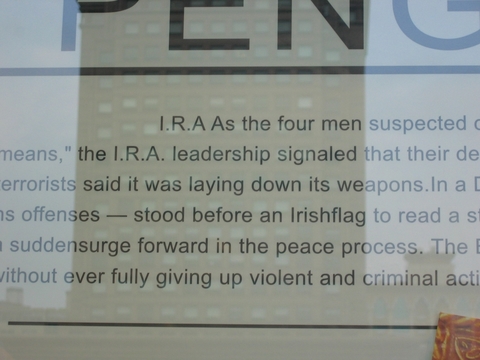 Clothing store window display in Taipei, Taiwan with IRA news story in background