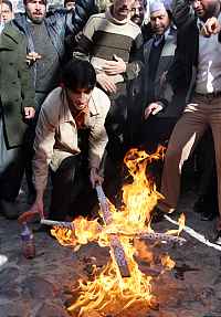 Muslim rioter burning a cross
