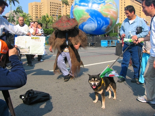 Man in traditional Taiwanese rain gear dancing at March 18, 2006 march