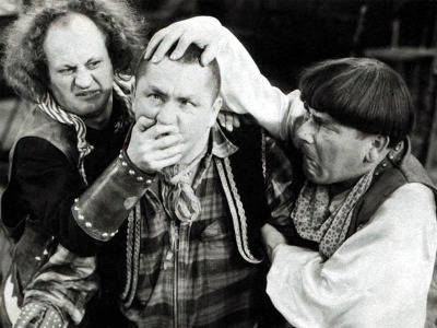 The Three Stooges. Larry and Moe hold Curly's head.