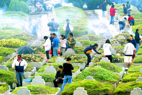 Taiwanese at a cemetery burning incense and paying obeisance to their ancestors.