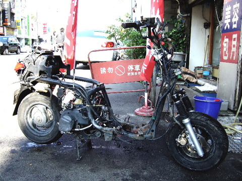 Stripped scooter on sidewalk of Taiwna showing all internal parts