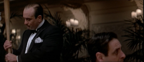 Al Capone (Robert de Niro) holds a bat behind a disloyal gangster. From The Untouchables.