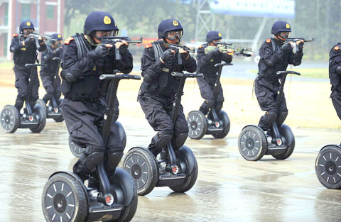 Chinese traffic police on Segways aim small submachine guns during a paramilitary anti-terrorist exercise prior to the 2008 Olympics in Beijing.