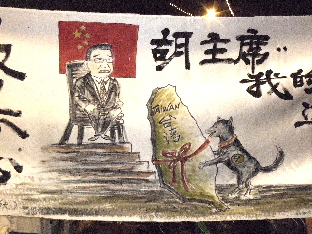 A closeup of a dog with the number 9 on its side (representing Ma Ying-jeou) delivering Taiwan to an enthroned Hu Jintao. From the evening of the Oct 25, 2008 anti-Ma rally in Taipei, Taiwan.