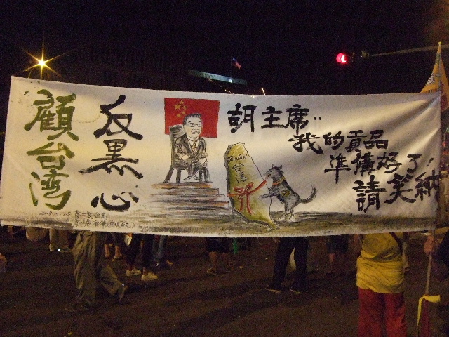 A dog with the number 9 on its side (representing Ma Ying-jeou) delivers Taiwan to an enthroned Hu Jintao. From the evening of the Oct 25, 2008 anti-Ma rally in Taipei, Taiwan.