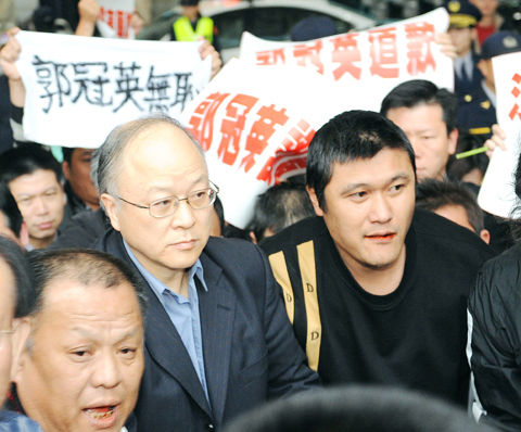 KMT civil servant Kuo Kuan-ying, graying and balding with glasses. Kuo considers himself much better than his fellow Taiwanese, fancying himself a 'high-class mainlander' instead.