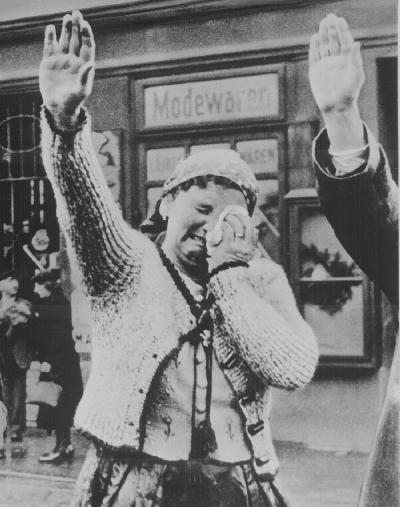 A woman cries while giving the Nazi salute to a passing German parade during the Anschluss.