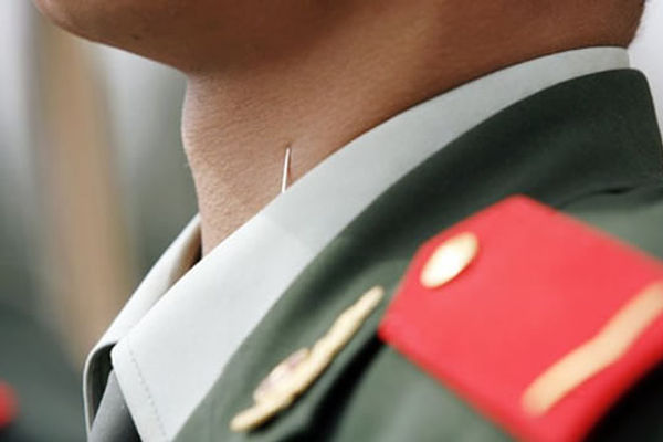 Close-up of People's Liberation Army soldier with needles in his collar.