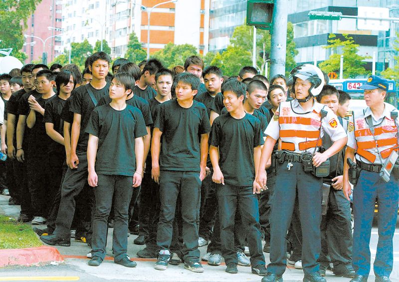 A large group of Taiwanese mafia foot soldiers, each wearing black t-shirts and matching pants.