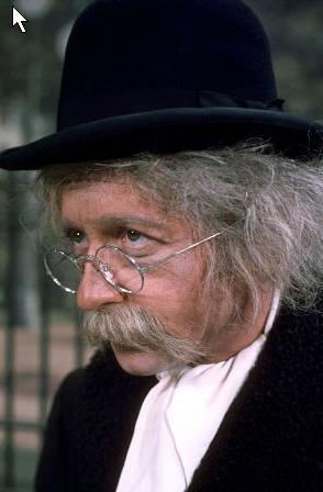 Arte Johnson as Tyrone F. Horneigh from Laugh-In. Horneigh wears spectacles, a black suit, and matching hat.