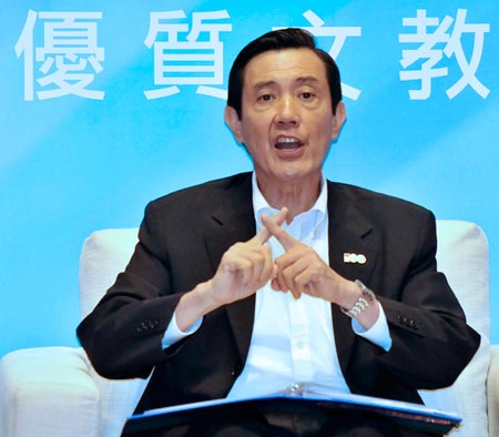 Taiwanese KMT President Ma Ying-jeou sits and crosses index fingers from both hands.