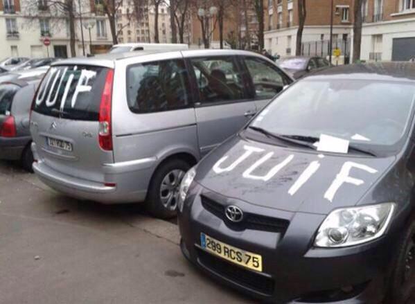 Two Parisian cars spray-painted with the word, 'Juif' (Jew).
