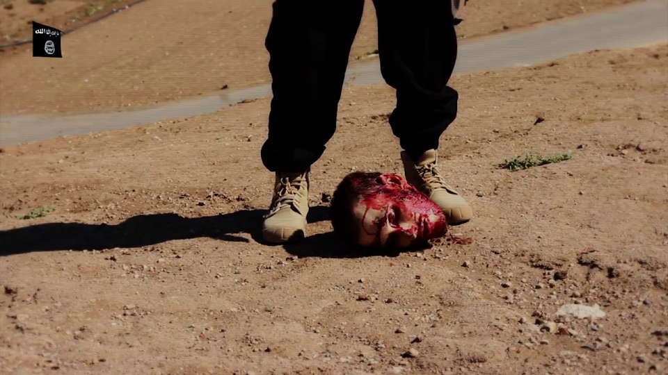 The decapitated head of American aid worker Peter Edward Kassig lies at the feet of an ISIS terrorist.
